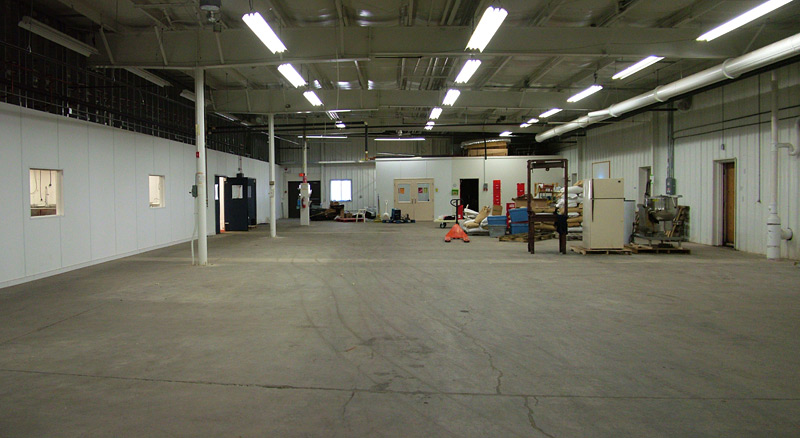 A vacant portion of the 60,000 square foot building that will likely be used to expand the commercial kitchen, visible at left. (Photo by Ethan Andrews)