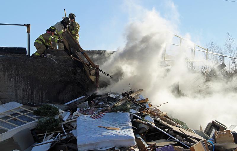 Rockland firefighters pick away at a debris pile fire at the Rockland Solid Waste Facility Saturday afternoon. (Photo courtesy Rockland Fire Department/by Alan Athearn)