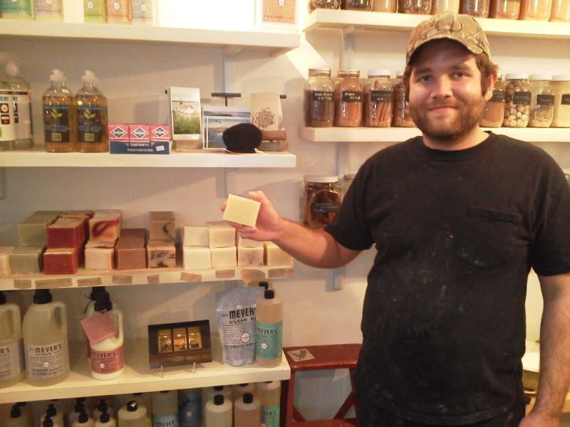 Rick Soloman, co-manager of Sweets and Meats, shows off shelf space for Trillium Soaps (Photo by Kay Stephens)