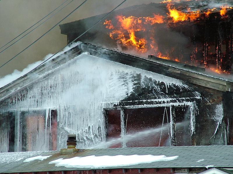 Bruce Woodwar's use of foam is credited with saving this residence, located just feet from the woodshop burning behind it. (Photo by Holly S. Edwards)