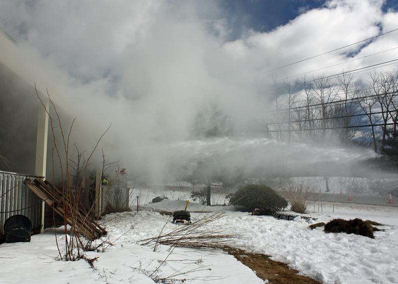 Using a stream of water to vent smoke out of the building. (Photo by Holly S. Edwards)