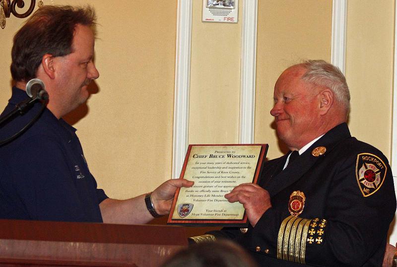 Hope Fire Chief Clarence Keller hands a plaque to Bruce Woodward, naming him Honorary Life Member of the Hope Volunteer Fire Department. (Photo by Holly S. Edwards)