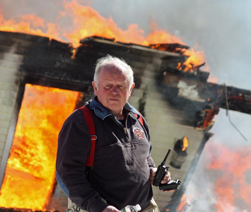 Rockport Fire Chief Bruce Woodward helped fight the house fire on Lily Pond Drive in Camden March 26, a roaring inferno that some will view as a fitting end to his 42-year career as chief. Bruce retires March 29, and on March 30 a parade will lead the community to a party in his honor at the place where he fought his biggest a year into the job -- the Samoset Resort. (Photo by Holly S. Edwards)