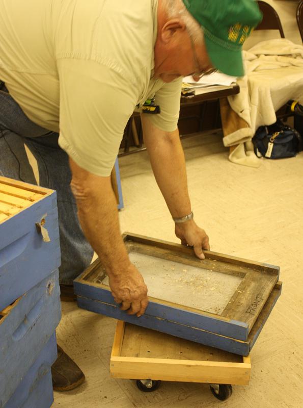 Peter Lammert and a screen bottom board, though which detritus and mites fell down onto for disposal. (Photo by Holly S. Edwards)