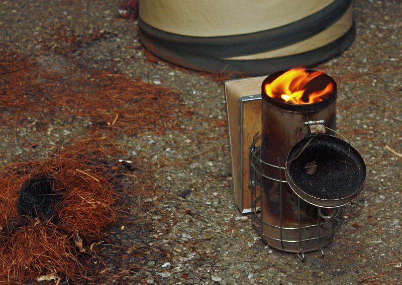 With some flame, it's time to jam more stuff on top so it smolders and smokes, not burns and flames. (Photo by Holly S. Edwards)