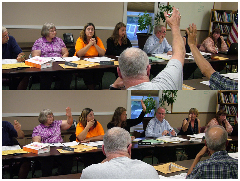 The two facing tables used by the RSU 20 board on Tuesday reflected the split between opposing philosophies. A vote in favor, top, and against, bottom. (Photo by Ethan Andrews)