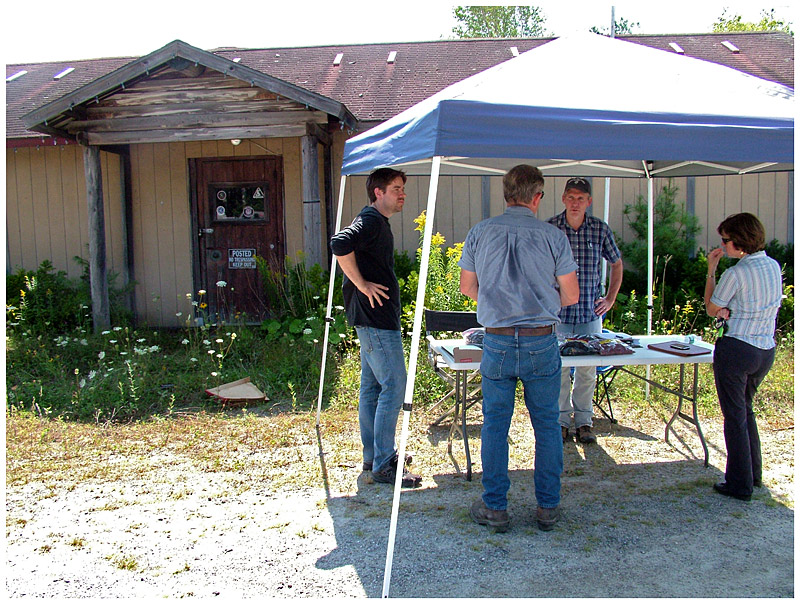 A group poses questions to Michael Parker of the Maine Department of Environmental Protection at a bidders conference held at the former shooting range, Aug. 21. (Photo by Ethan Andrews)