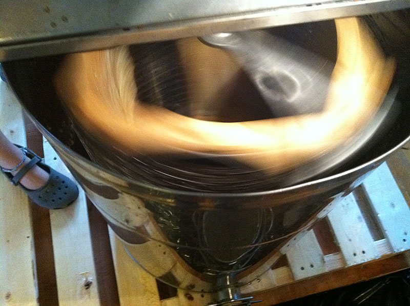 Four frames of honey spin in the extractor, which uses centrifugal force to pull the honey from the cells and into the steel container. (Photo by Holly S. Edwards)