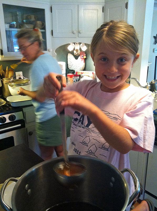 What child wouldn’t love the job of scooping her own jar of honey that she just helped harvest? Kyra is pleased. (Photo by David Edwards)