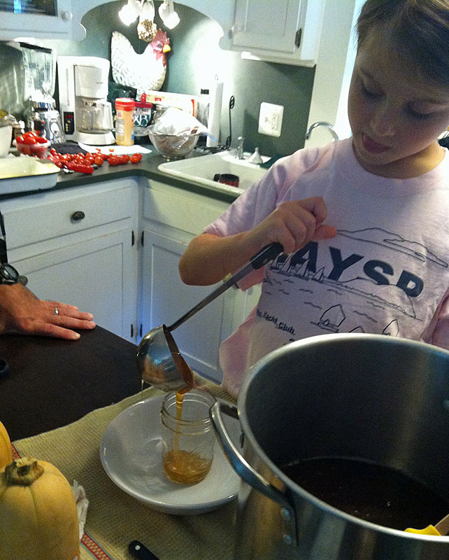 It takes a steady hand and lots of concentration to transfer honey into a jar. (Photo by Holly S. Edwards)