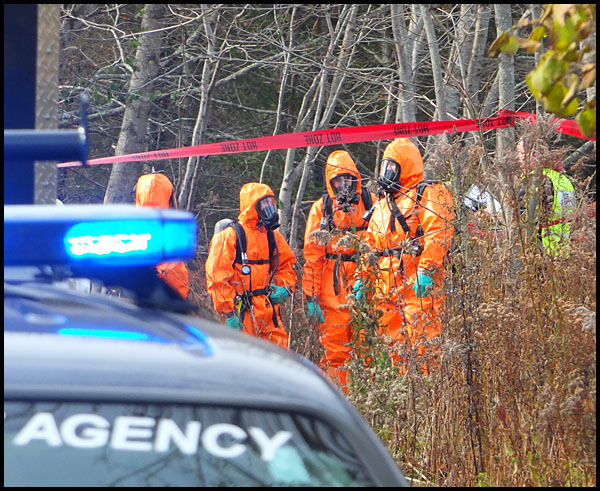 MDEA agents and other investigators wear protective clothing during the search for evidence of a suspected meth lab operation on South Shore Drive in Owls Head Friday. (Photo by Chris Wolf)