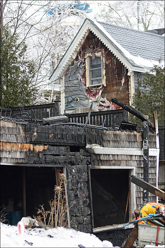 David Cameron’s house next door to 245 Shore Road sustained melted siding and smoke damage. In addition, some of his storm windows broke in the fire and firefighters had to break in to access the house overnight. Cameron was busy Tuesday boarding up the windows and doors. (Photo by Holly S. Edwards)