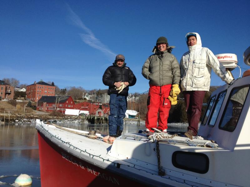 From left, Mike Young, of Rockport Public Works, Rockport Harbormaster Abbie Leonard and volunteer Aiden Gordon place more lights on lobster boats during the day Saturday in Rockport Harbor. (Photo by Peter Ralston)