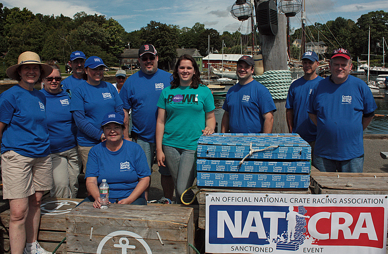 Camden National Bank employees volunteered to help out at the Lobster Crate Races, which the bank sponsored. They gave each racer a beach towel to dry off and furnished the prizes for the first, second and third place finishers. (Photo by Holly S. Edwards)