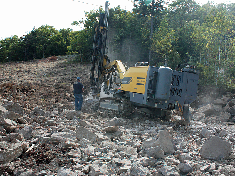 Breaking up rocks following a blast into ledge. (Photo by Holly S. Edwards)