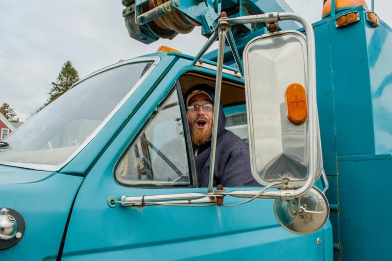 Elisha "Lysh" Brown, who works for Thayer's Boatyard and it owner Ryan Haskell, brought a truck and their large crane to try to right the trucks Thursday. (Courtesy Seth Macy)
