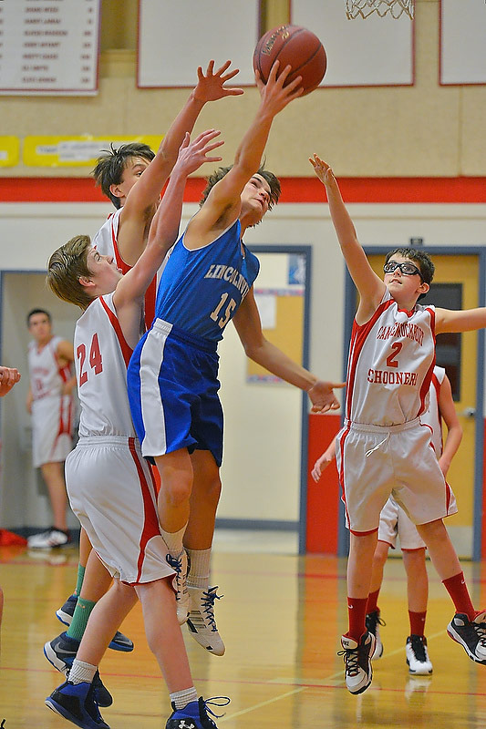 Lincolnville’s Michael Kremin, center, drives to the basket for two of his team high 20 points. Kremin had five 3-pointers in the game. (Photo by Ron Hawkes)