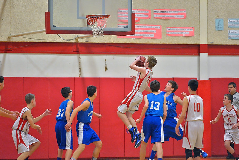 Camden’s Sam Hebert, center, drove hard to the basket, splitting the defense for two points. (Photo by Ron Hawkes)