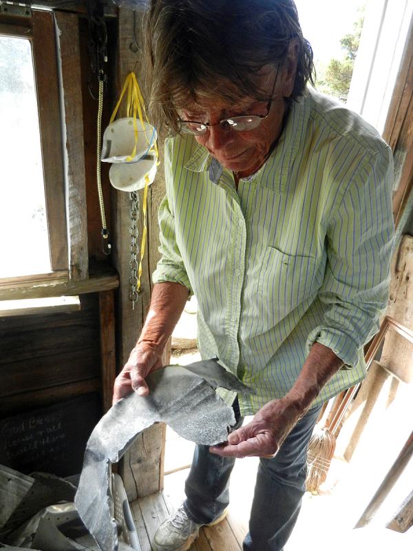 Blair examines a piece of sheet metal.