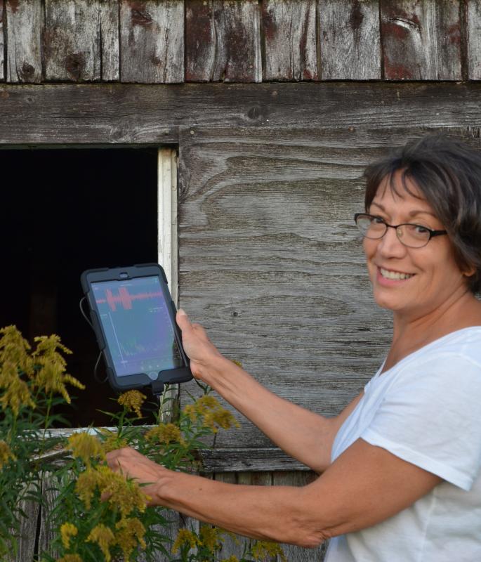 Annie Kassler and bat spectrometer investigate an old Rockport barn. (Photo by Lynda Clancy)