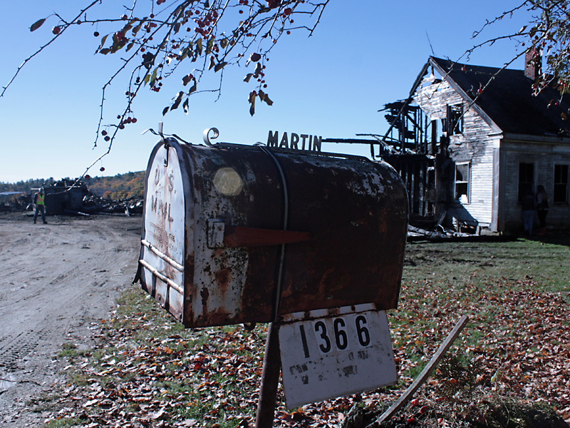 Family members look in the window of the burned out farmhouse that has been in the Martin family for nine generations. (Photo by Holly S. Edwards)