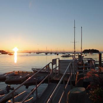 The sun crosses the horizon and shines on Camden Harbor and Curtis Island. (Photo by Holly S. Edwards)