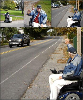 Kert Ingraham doing what he does, waving to passersby from his perch at the edge of 63 Washington St. in Camden (Photos by Chris Wolf)