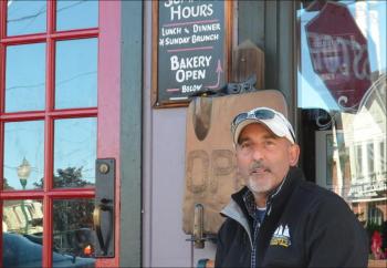 David Robichaud sits outside Cappy's Chowder House on the famous bench, which accommodates locals and visitors for conversation. (Photo by Lynda Clancy)