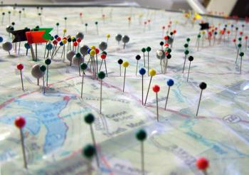 Pins on a map of the 11-town Regional School Unit 3 in the office of Transportation Director Raymond Shute — color coded to indicate different bus routes. The district recently switched from multiple grade-segregated bus runs to a "single-run" system that aims to be more efficient. (Photo by Ethan Andrews)
