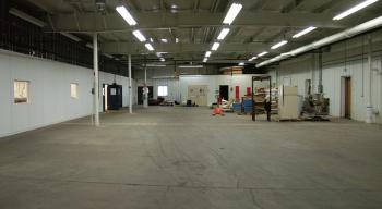A vacant portion of the 60,000 square foot building that will likely be used to expand the commercial kitchen, visible at left. (Photo by Ethan Andrews)