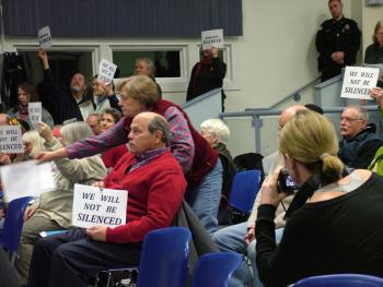 Opponents of the proposed propane terminal hold up signs in protest of the Searsport Planning Board's decision to end public comment with a dozen citizens waiting in line to speak. (Photo by Ethan Andrews) Opponents of the proposed propane terminal hold up signs in protest of the Searsport Planning Board's decision to end public comment with a dozen citizens waiting in line to speak. (Photo by Ethan Andrews)