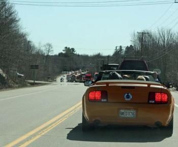 Riding in a bright orange Mustang, Fire Chief Bruce Woodward and his family follow the parade down Route 1 toward the Samoset Resort, near the Rockland town line. (Photo by Holly S. Edwards)