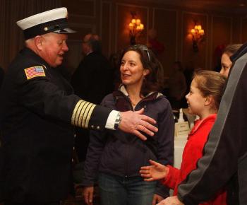Bruce Woodward greets a family that lives behind his home in Rockport, and once had a chimney fire, giving them a chance to meet. (Photo by Holly S. Edwards)