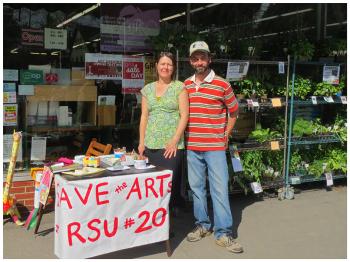 Nancy Brown, right, a teacher in RSU 20, and her husband Rob Brown set up a table outside the Belfast Co-op on May 28 in support of reinstating art positions slated to be cut in next year's budget. Theirs was among a number of organized efforts to bring out voters to Wednesday night's public budget meeting. (Photo by Erica Thoms)