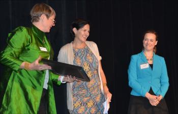 At the Maine Women's Fund annual Leadership Luncheon May 23 the organization's Chief Executive Officer Sarah Ruef-Lindquist bestows the Sarah Orne Jewett award on photographer Samantha Appleton, of Camden, for her true grit, independence, courage, humor and discipline. To her left is Suzanne Nance, music director, producer and host at Maine Public Broadcasting Network. (Photo by Lynda Clancy)