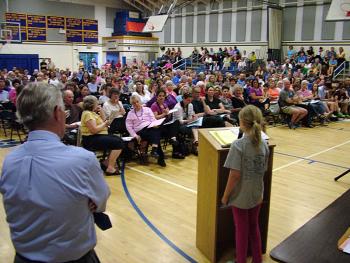 Kaitlyn Dufflemeyer, a fourth grade student at Edna Drinkwater Elementary School, addresses a crowd of 300 in the Troy Howard Middle School gymnasium during the public budget meeting for Regional School Unit 20, May 30. Dufflemeyer was among a number of people to speak in support of reinstating art positions slated to be cut in the 2013-14 budget. (Photo by Ethan Andrews)