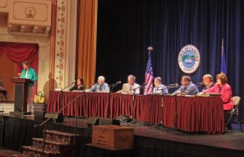 Deborah Dodge moderates the June 12 Camden Town Meeting at the Opera House, with Select Board members and Town Manager Patricia Finnigan under the lights on stage. (Photo by Holly S. Edwards)