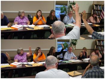 The two facing tables used by the RSU 20 board on Tuesday reflected the split between opposing philosophies. A vote in favor, top, and against, bottom. (Photo by Ethan Andrews)