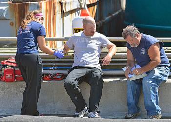 Two of the uninjured crewmen who helped rescue the two injured men from the hold moments before emergency crews arrived are checked out. (Photo by Ron Hawkes)