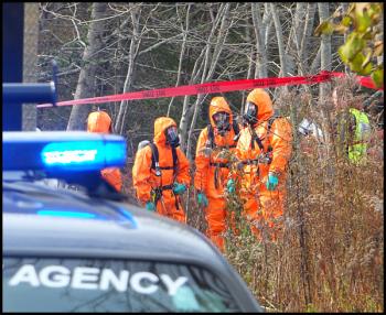 MDEA agents and other investigators wear protective clothing during the search for evidence of a suspected meth lab operation on South Shore Drive in Owls Head Friday. (Photo by Chris Wolf)