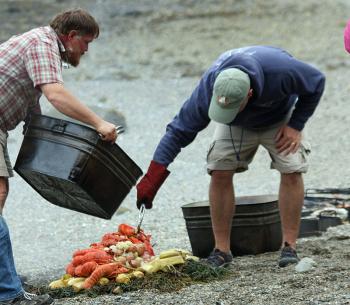Capt. Barry King and Ethan Rhile prepare the lobster bake for presentation on Lobster Island in East Penobscot Bay. (Photo by Holly S. Edwards)