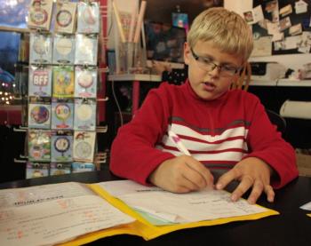 Jacob Murray adds up his latest Brain Cupcake sales and donations Tuesday afternoon, all of which will be donated Saturday, Nov. 22, to the National Brain Tumor Society in honor of his best friend Will Smith’s dad, Billy Smith. (Photo by Holly S. Edwards)