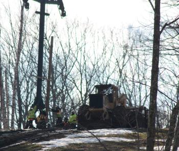 As the tower gets closer to the footing, it is grabbed onto by six or eight workers, some of them Parks and Recreation employees, and manuevered over the bolts on the footing. (Photo by Holly S. Edwards)