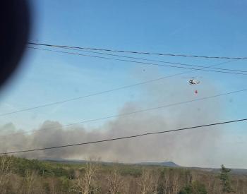 A Maine Forest Service helicopter flies over the fire in Searsmont, which was reported to Waldo County Regional Communications at 4:53 p.m. Thursday, May 7. (Courtesy Bob Hall)