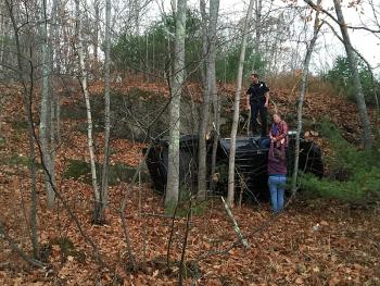 After saying he lost control while driving into Camden on Route 105, Guyer ‘Gordon’ Guist’s Chevrolet Colorado pickup truck flew over the rock ledge in the background and landed on the ground below, stopped by a stand of trees. (Photo by Holly S. Edwards)