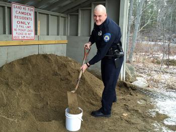 Camden Police officer Tim ‘The Sandman’ Davis shovels a bucket full of sand in preparation for delivery to a senior in need of some safe footing outside their home. Camden, like many towns, has a public sand pile where residents can fill a bucket to bring sand home and spread on their sidewalks and walkways. The new ‘Sand for Seniors’ program will get sand on a regular basis into the hands of residents who otherwise couldn’t pick it up and bring it home themselves.(Photo by Holly S. Edwards)