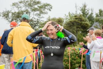 Swimmer Katie Urey is all smiles at the finish. Several dozen volunteers from Islesboro provided hot coffee and home baked goods for the swimmers, paddlers and volunteers at the finish. (Photo courtesy Michele Barker)