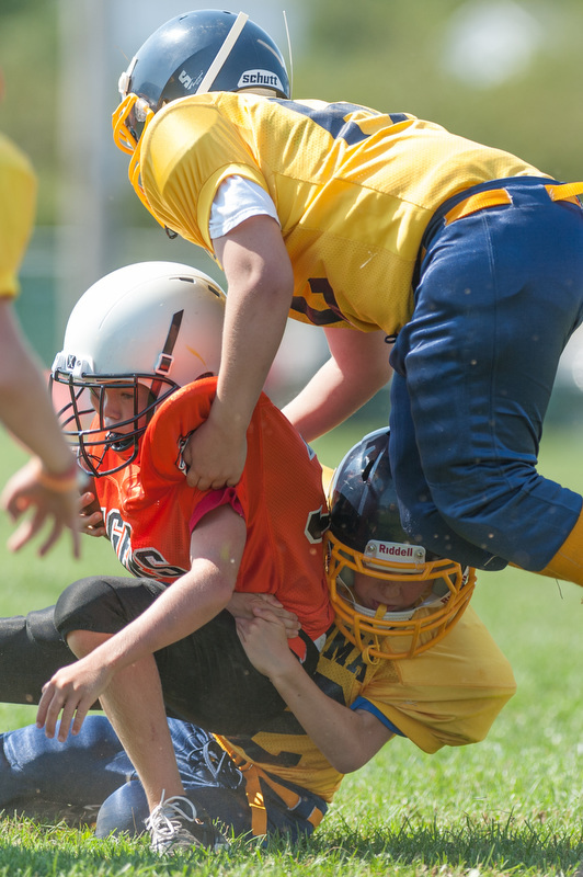 Two Medomak tacklers bring down a Rockland runner close to the end zone. Photo by Ron Hawkes