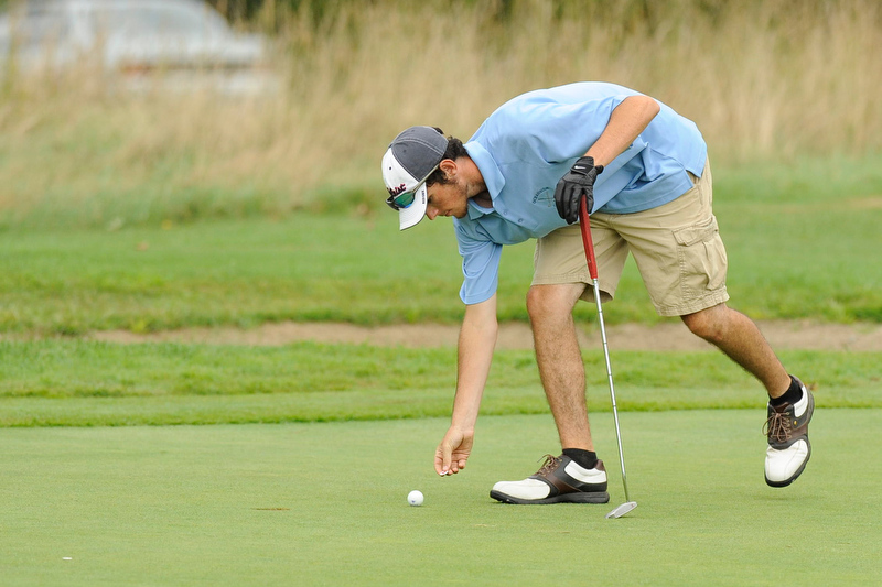Oceanside's Jordan Carter marks his ball near the cup after a nice chip shot onto the green. Photo by Ron Hawkes