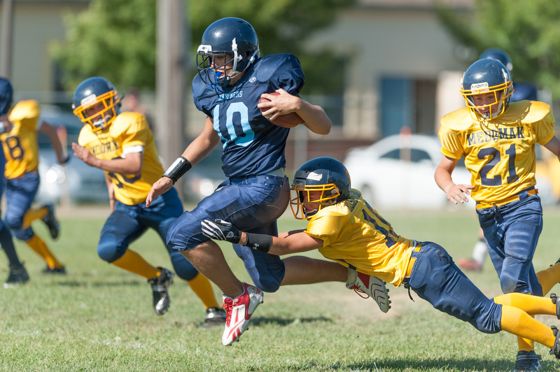 Oceanside's Chris Christians breaks a tackle and goes all the way for his first of three touchdowns on the day. Photo by Ron Hawkes